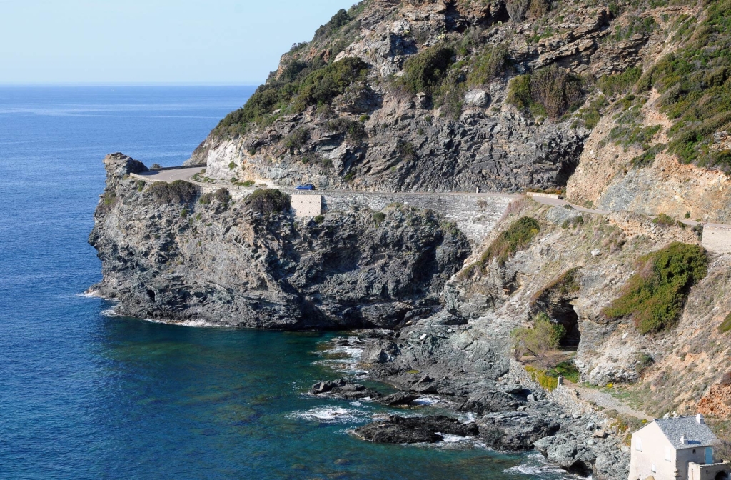 A car driving along the spectacular west coast of the Cap Corse peninsula.