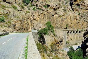 Windy narrow road meandering along the banks of the Golo river.