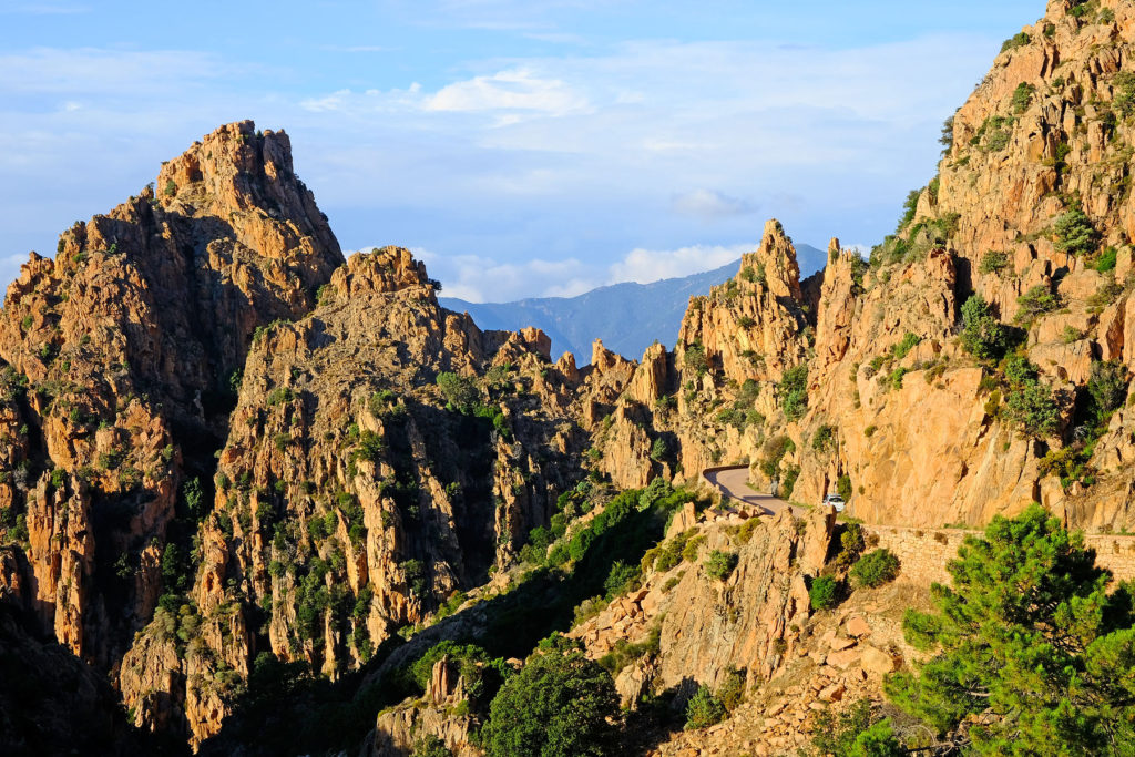 Corniche road meandering through the world of red granite rock formations of the fascinating Calanches de Piana.