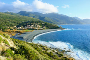 Wild waves crashing against a windswept pebbly beach of Marine d'Albo.