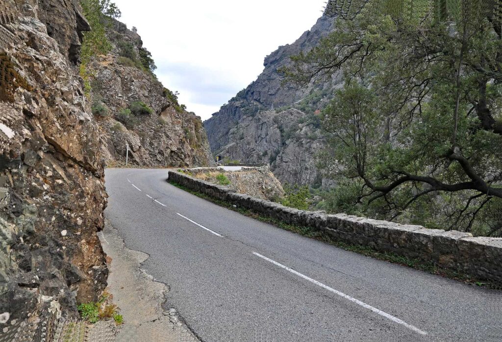 Narrow and winding, the road through Défilé de l’Inzecca features tight turns and dramatic rock walls.