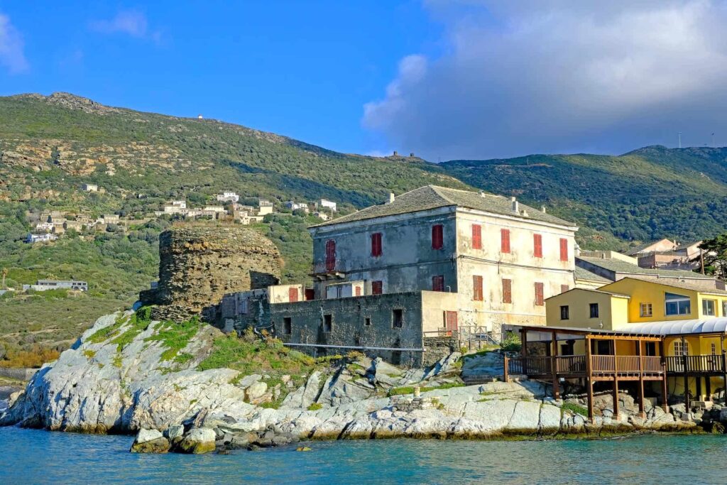 Centuri's pastel-coloured houses are set against a dramatic rocky coastline.