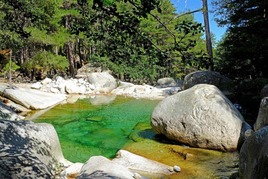Restonica’s emerald waters carve their way past waterfalls and rock formations in one of Corsica’s most scenic valleys.