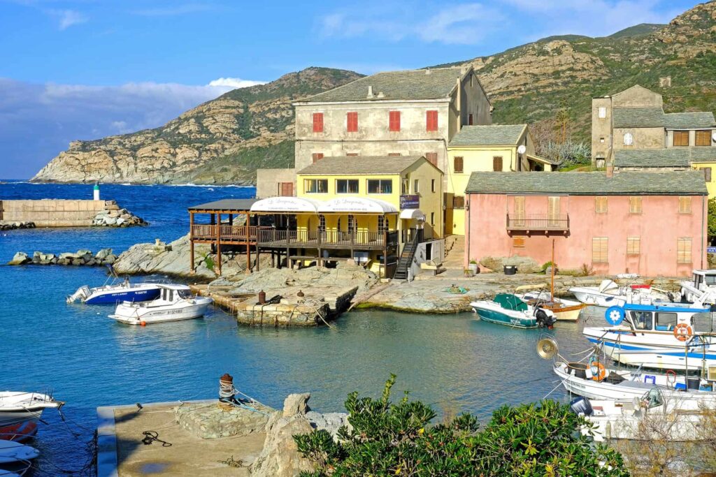 The small port of Centuri teems with local life, fresh seafood, and boats lined up along the shore.