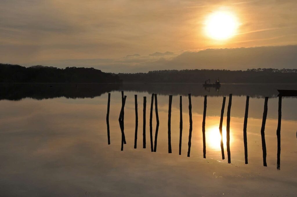 Urbinu’s tranquil lagoon offers stunning reflections of the sky and surrounding forests, perfect for quiet contemplation.