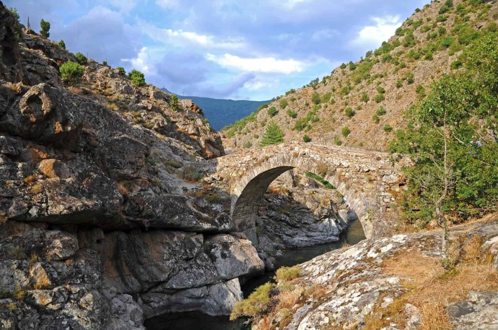 The Genoese bridge in Asco arches gracefully over the mountain stream, a testament to Corsican craftsmanship.