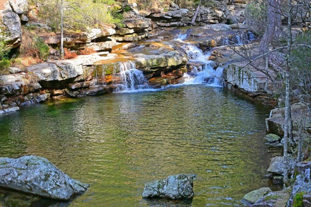 The mountain stream gathers in rocky basins, offering a relaxing pause on a warm day.