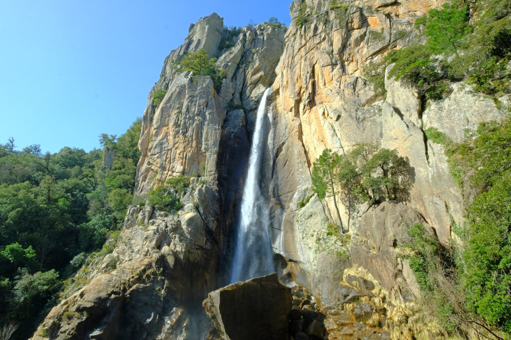 In the Bavella mountains, Piscia di Gallo plunges down a sheer cliff with force before crashing into a large natural pool.