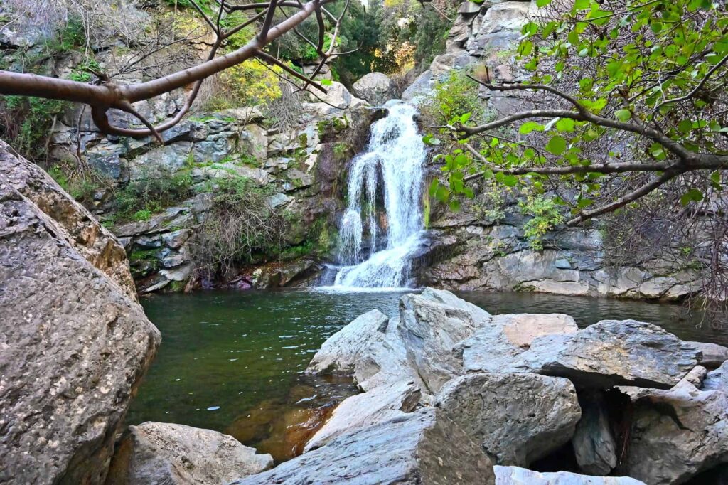 The Bucatoghju waterfall flows into a deep natural swimming pool, bringing relief from the coastal heat.