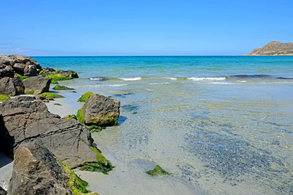 Quiet mornings at Ostriconi offer calm water before the afternoon breeze picks up.