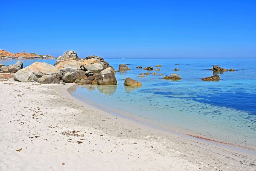 Beyond a rocky promontory extends a more peaceful part of the Ile Rousse beach.