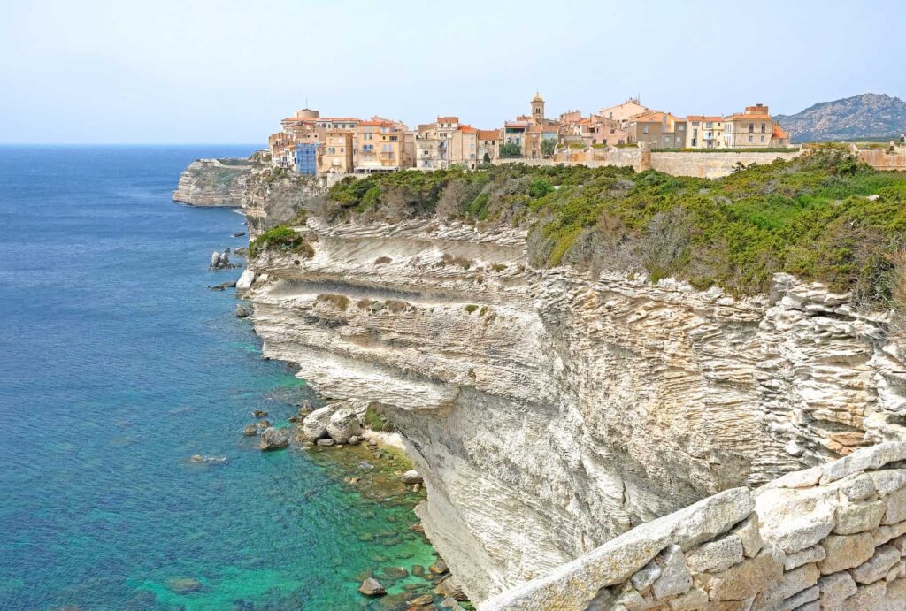 Bonifacio clings dramatically to white limestone cliffs above the sea on Corsica's southernmost tip.