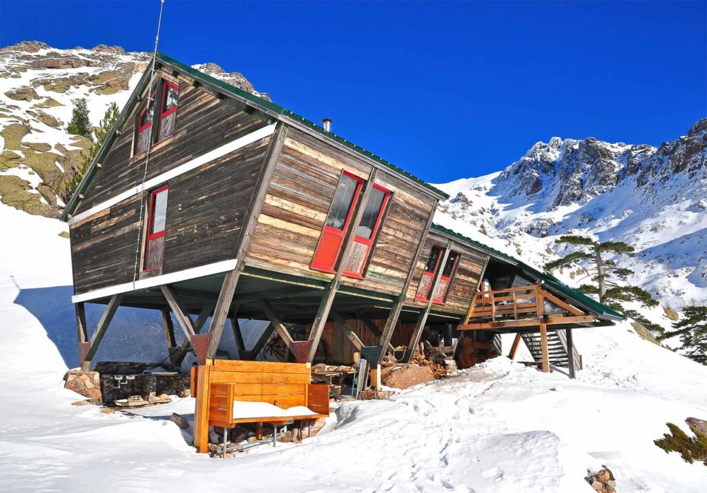 Winter often drapes a snow blanket over Refuge de Tighjettu's surrounding wilds.