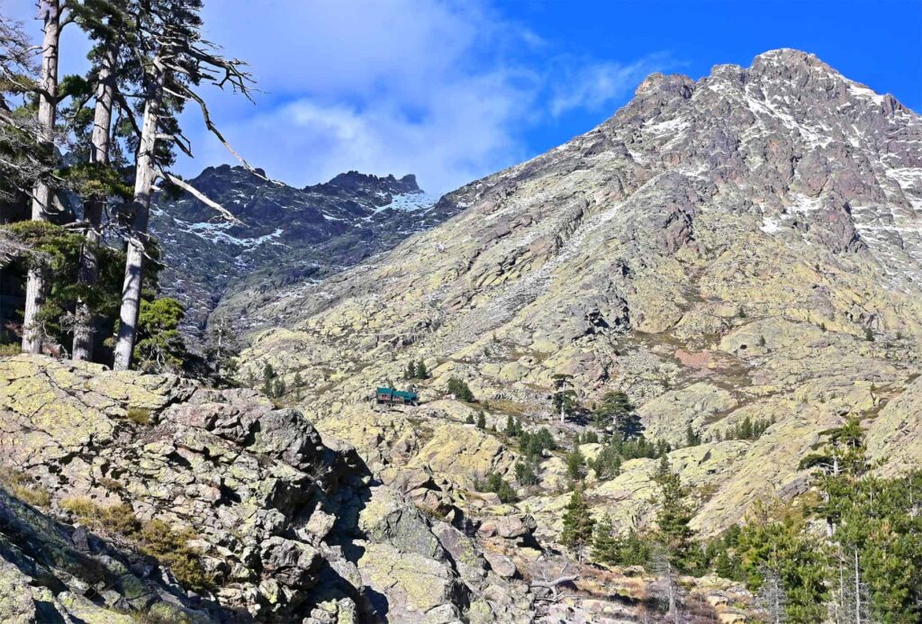 Overlooking a boulder-strewn valley, Refuge de Tighjettu perches on stilts under Corsica's loftiest peaks.
