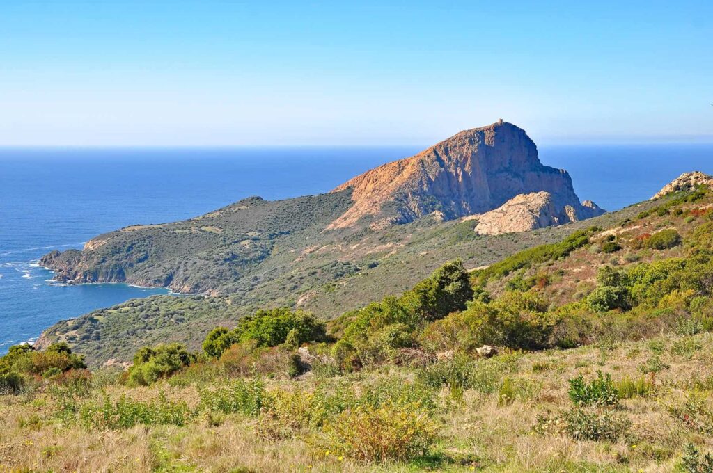 Turghiu Tower stands dramatically atop Capu Rossu's sheer cliffs overlooking the Mediterranean.